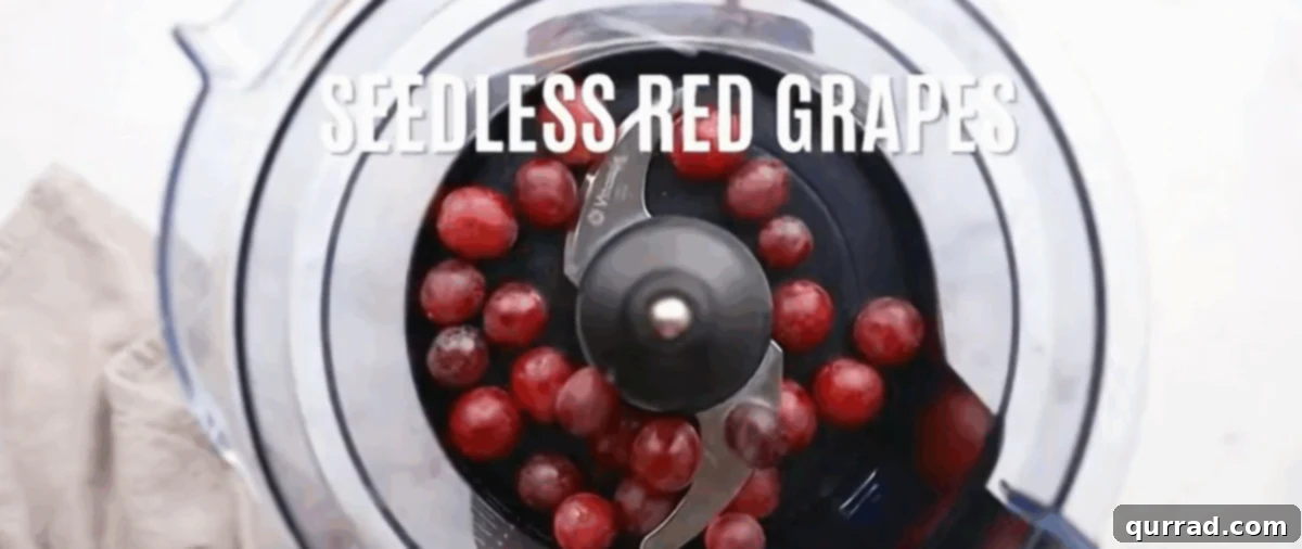 Step 3: Preparing the Grapes Bright red seedless grapes are placed inside a food processor bowl, ready to be crushed for the pie filling.