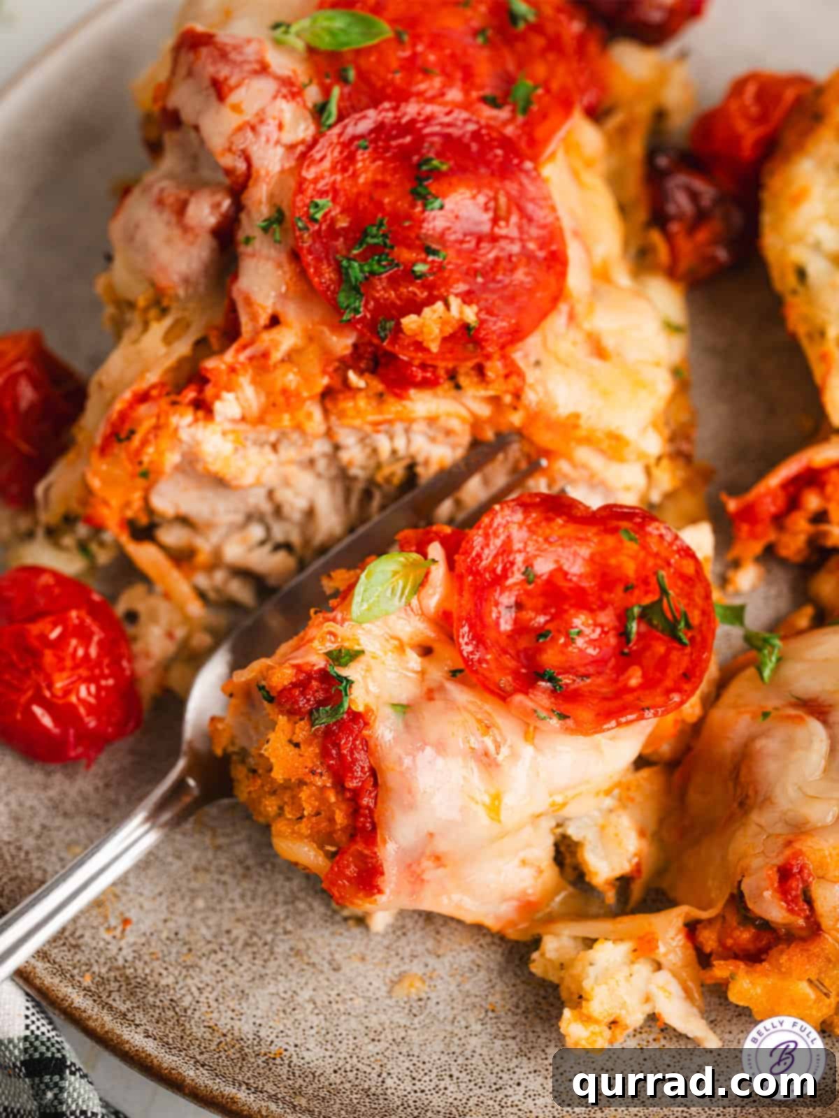 Close-up of Pizza Parmesan Chicken A fork cutting into a piece of pizza chicken parmesan, revealing the juicy chicken and melted cheese