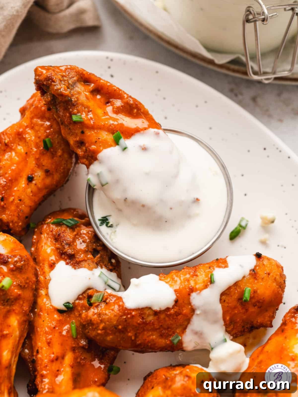 This Homemade Blue Cheese Dressing is made with blue cheese crumbles, buttermilk, sour cream, and a few other ingredients. A plate of chicken wings with a dish of blue cheese dressing