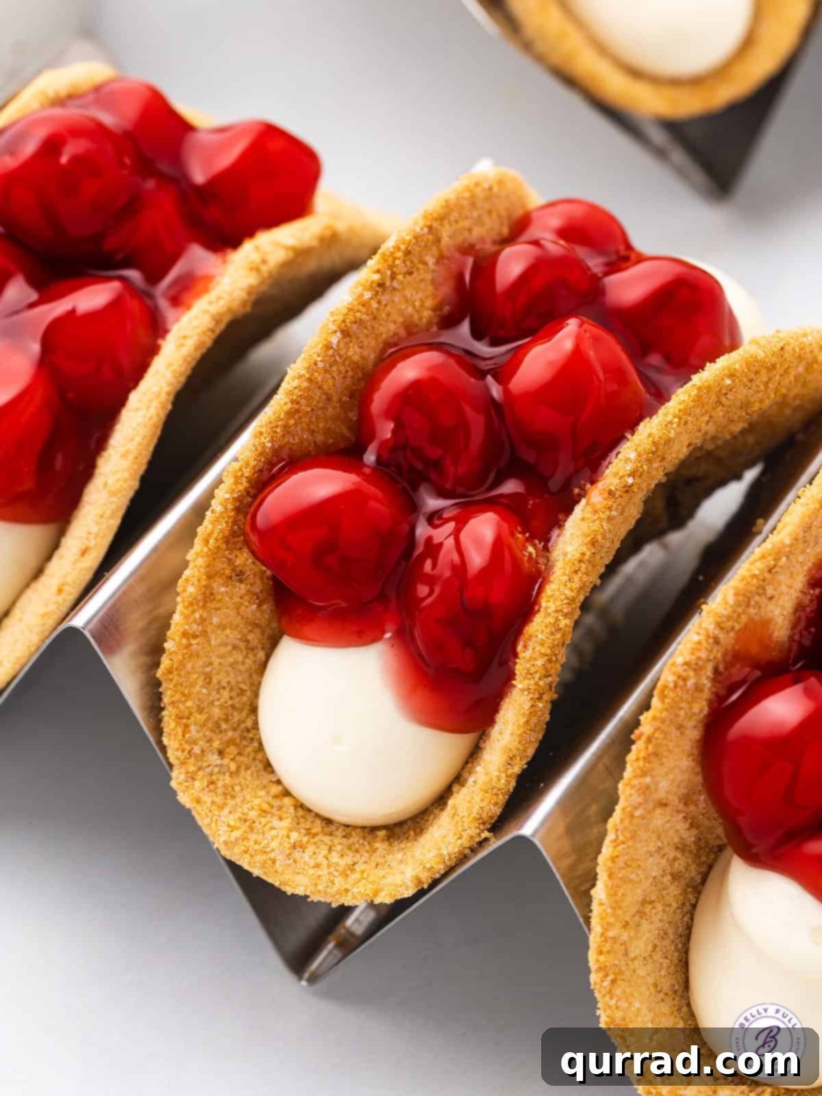 Perfectly presented Cherry Cheesecake Tacos in convenient taco holders. Cherry cheesecake tacos elegantly displayed in taco holders, ready to serve.