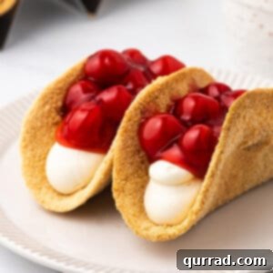 Two cherry cheesecake tacos on a plate, ready to be eaten