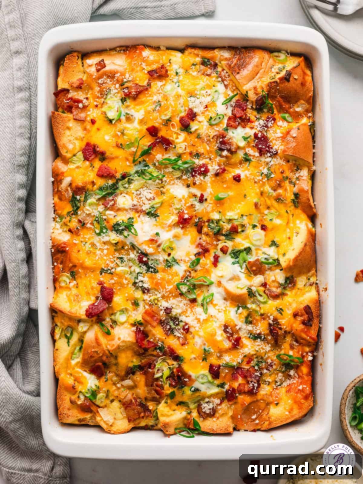 With thick-cut bacon, cheddar cheese, and a few spices, this Bagel Egg Bake is an easy savory option for breakfast or brunch. Overhead view of a bagel egg bake in a casserole dish, ready to be served