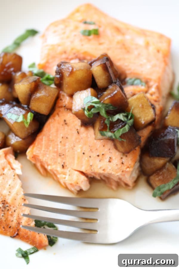 An overhead shot of broiled salmon fillets with the glistening caramelized balsamic-honey apples and a sprinkle of fresh snipped basil for garnish.