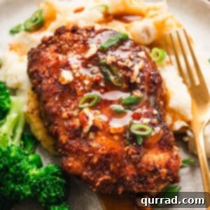 A pecan crusted chicken breast on a plate with potatoes and broccoli, ready to eat.