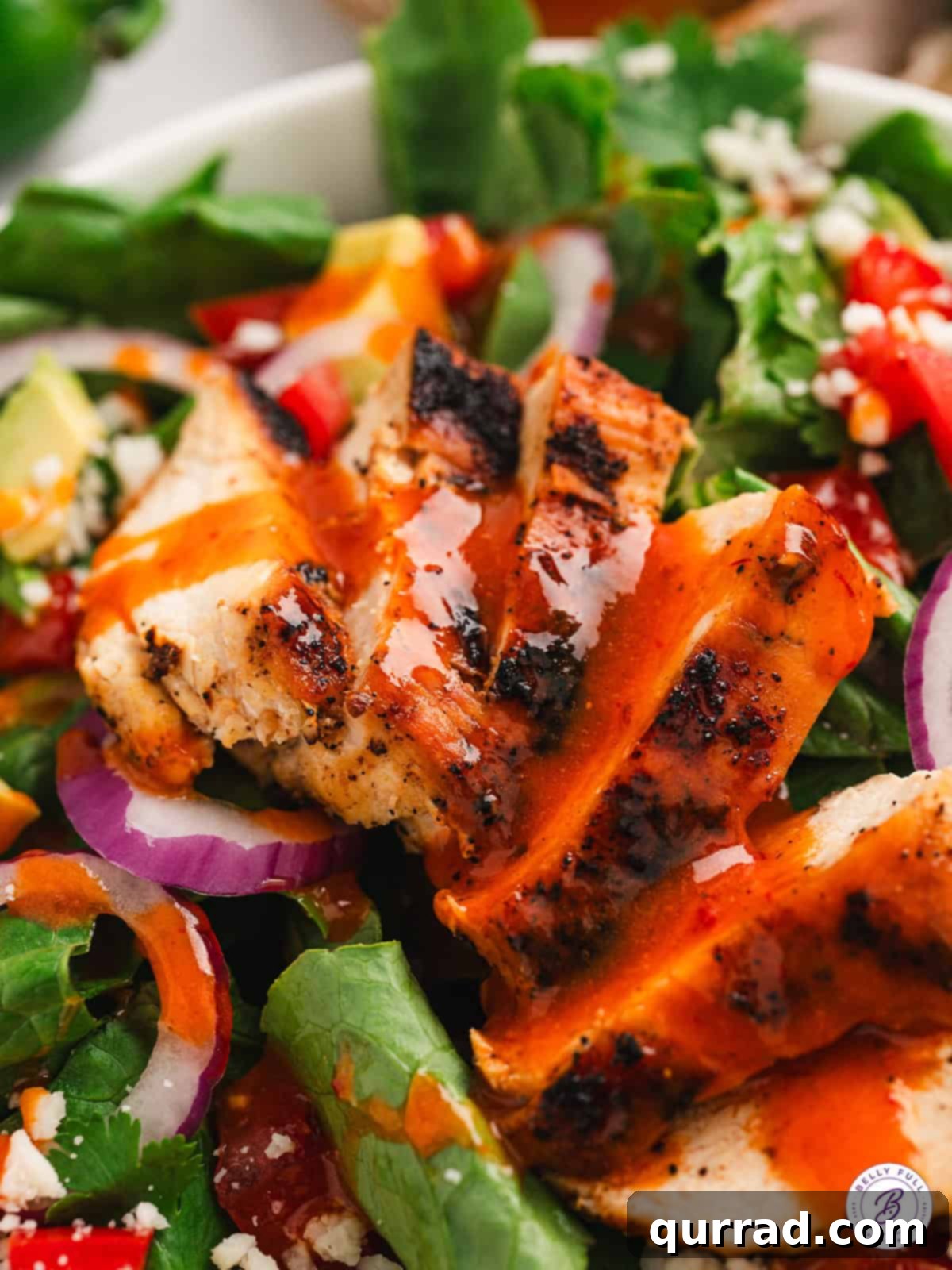 Chipotle honey vinaigrette is smokey and spicy with a tiny hint of sweetness. It's perfect for dressing salads, marinating meat, and more. A vibrant salad topped with grilled chicken and a generous drizzle of Chipotle honey vinaigrette, highlighting its appetizing appearance and versatile use.