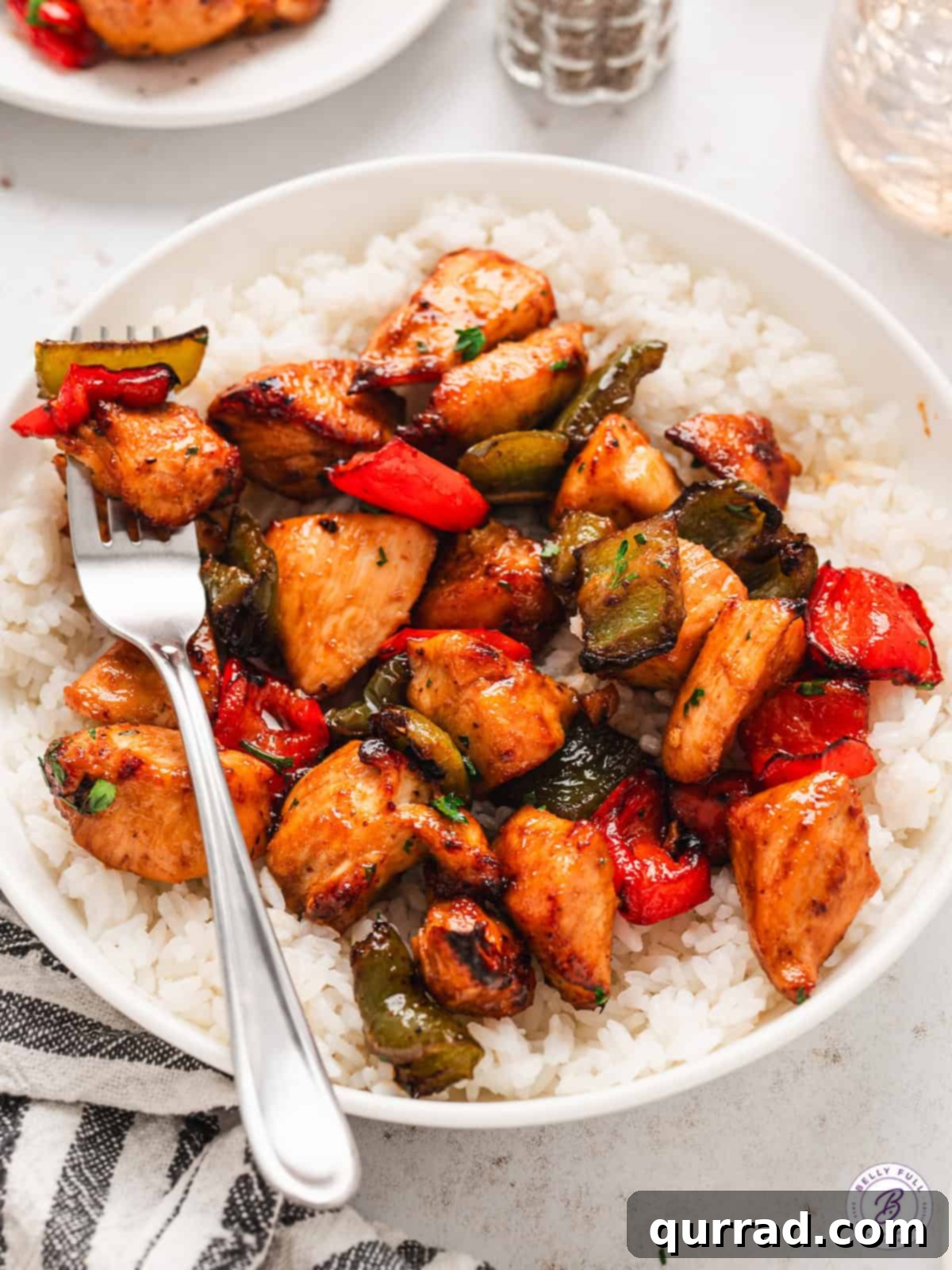 This air fryer chicken and peppers recipe comes together in just 25 minutes! It's savory, sweet, and just the right amount of spicy. Chicken and peppers served over rice.