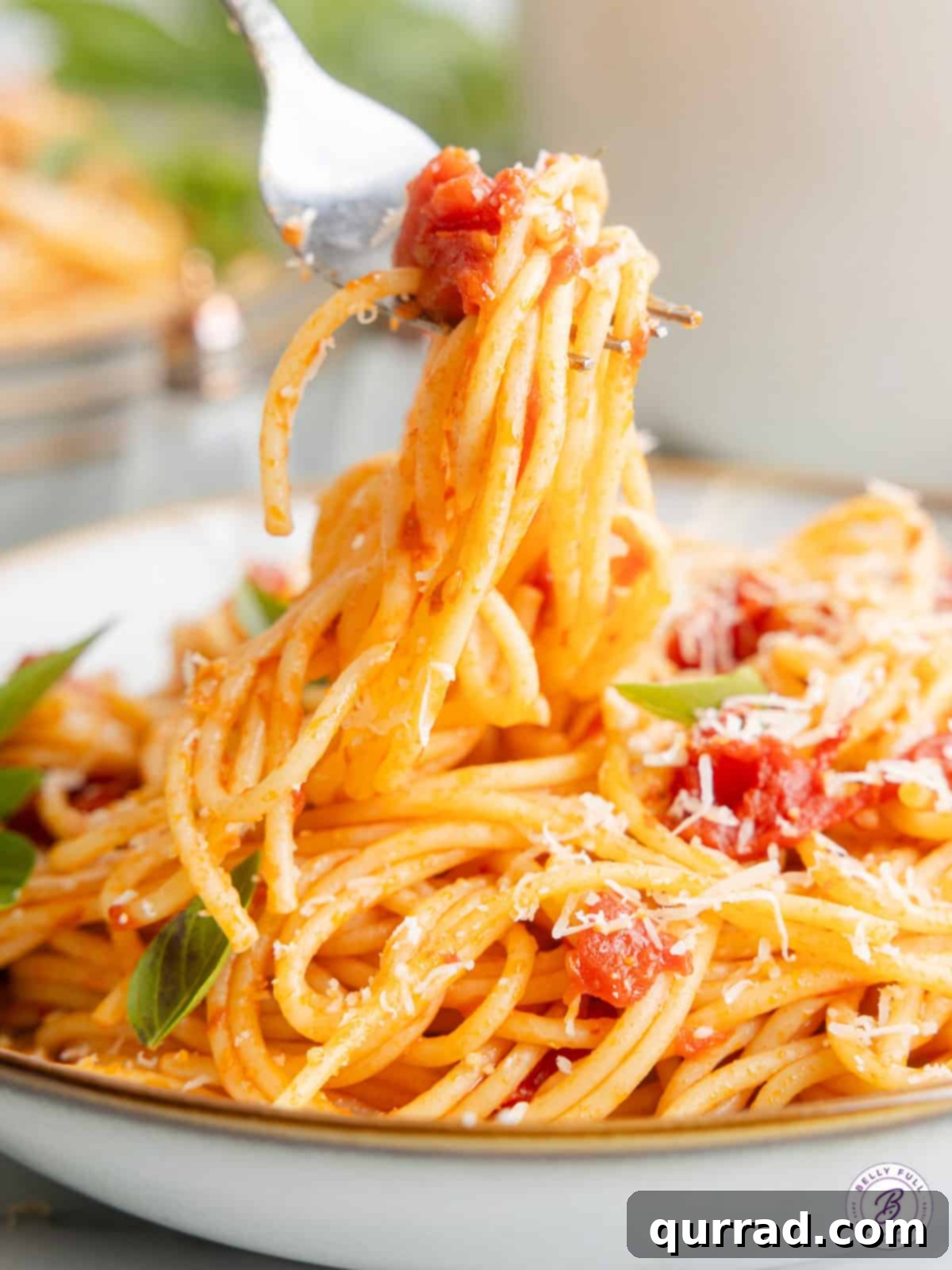 Savor every twirl of this classic Pasta Pomodoro, a delightful blend of simple ingredients creating an unforgettable Italian meal. A close-up shot of a fork lifting a perfect bite of Pasta Pomodoro from a bowl, highlighting the vibrant sauce and fresh basil garnish.