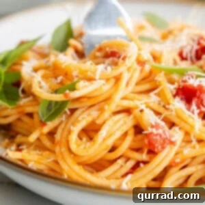 A fork twisting a bite of Pasta Pomodoro from a bowl, showcasing the simplicity and deliciousness of the dish.