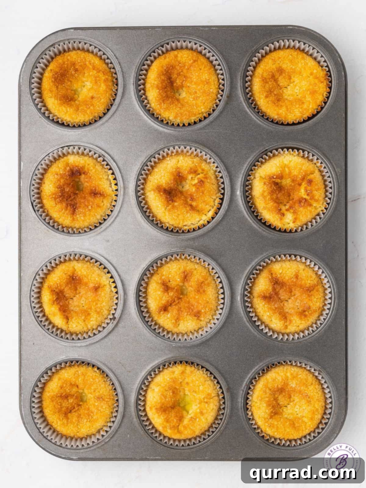 A cross between a creamy custard tart and an eggy macaroon, these Mini Coconut Cakes are a popular Portuguese dessert. Freshly baked Portuguese coconut tarts cooling in a muffin tin, ready to be enjoyed.