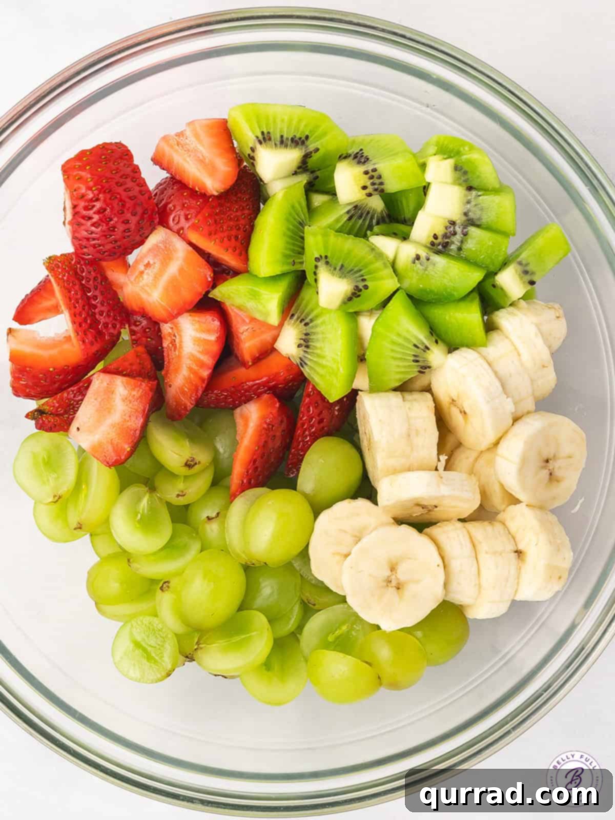 Vibrant Honey-Lime Fruit Medley 3 sliced strawberries, banana, kiwi, and green grapes in bowl