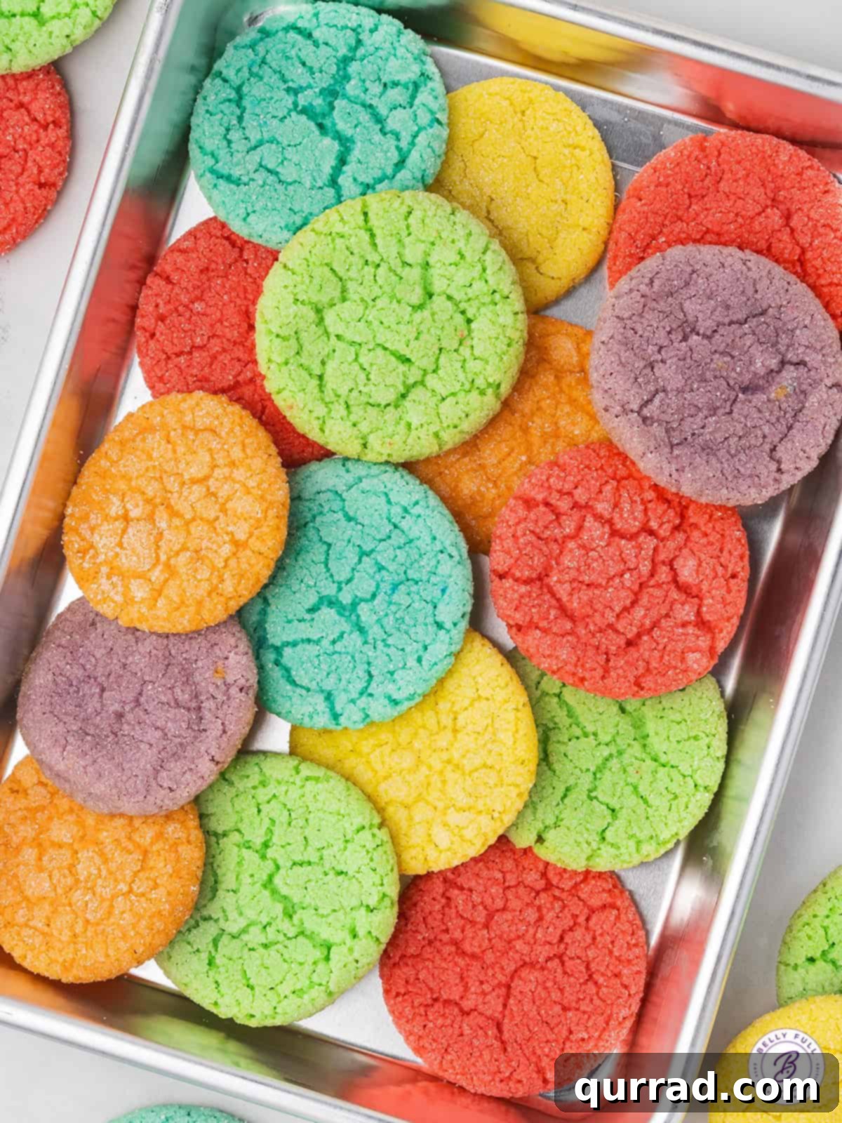 Colorful Jello Cookies cooling on a baking sheet, ready to be enjoyed. A baking sheet filled with freshly baked Jello Cookies, showcasing a variety of vibrant colors.