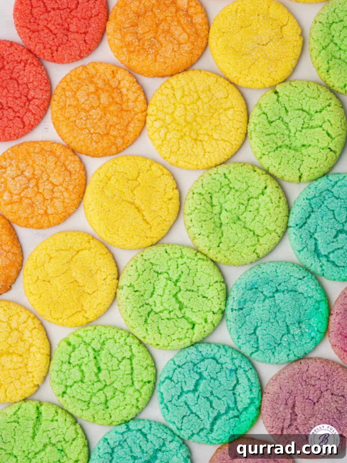 An appealing overhead view of a selection of Jello Cookies. Overhead shot of various colored Jello Cookies arranged on a baking sheet, ready for cooling.