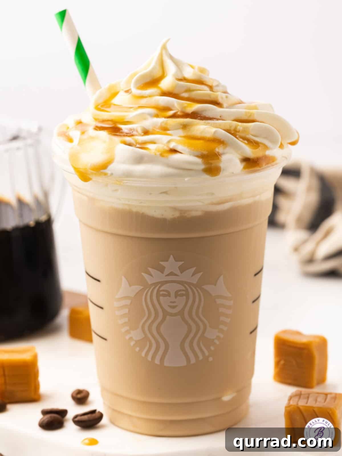 A beautifully garnished Copycat Starbucks Caramel Frappuccino, ready to be enjoyed. A close-up shot of a perfectly blended Copycat Starbucks Caramel Frappuccino in a clear glass, showing its creamy texture, topped with a peak of whipped cream and intricate caramel drizzles.