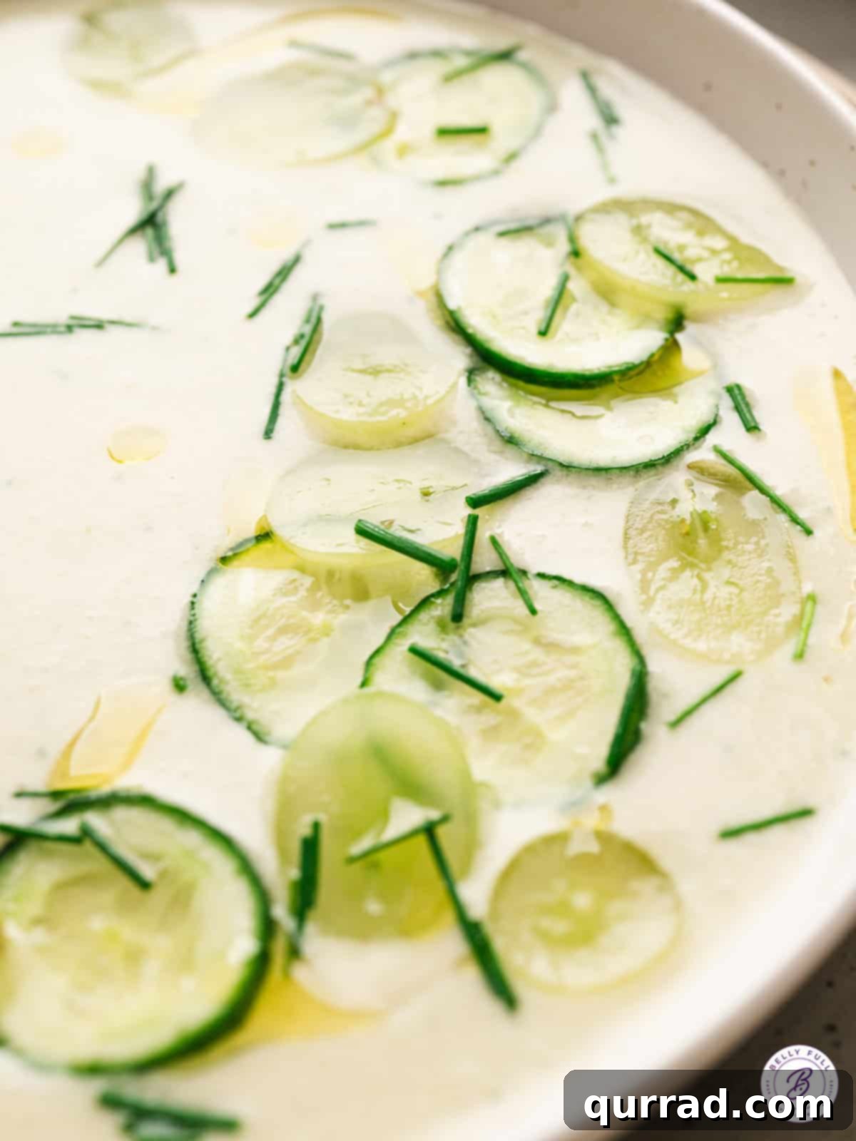 A close-up view of a bowl of cold cucumber soup, showcasing its smooth, creamy texture and vibrant green color.