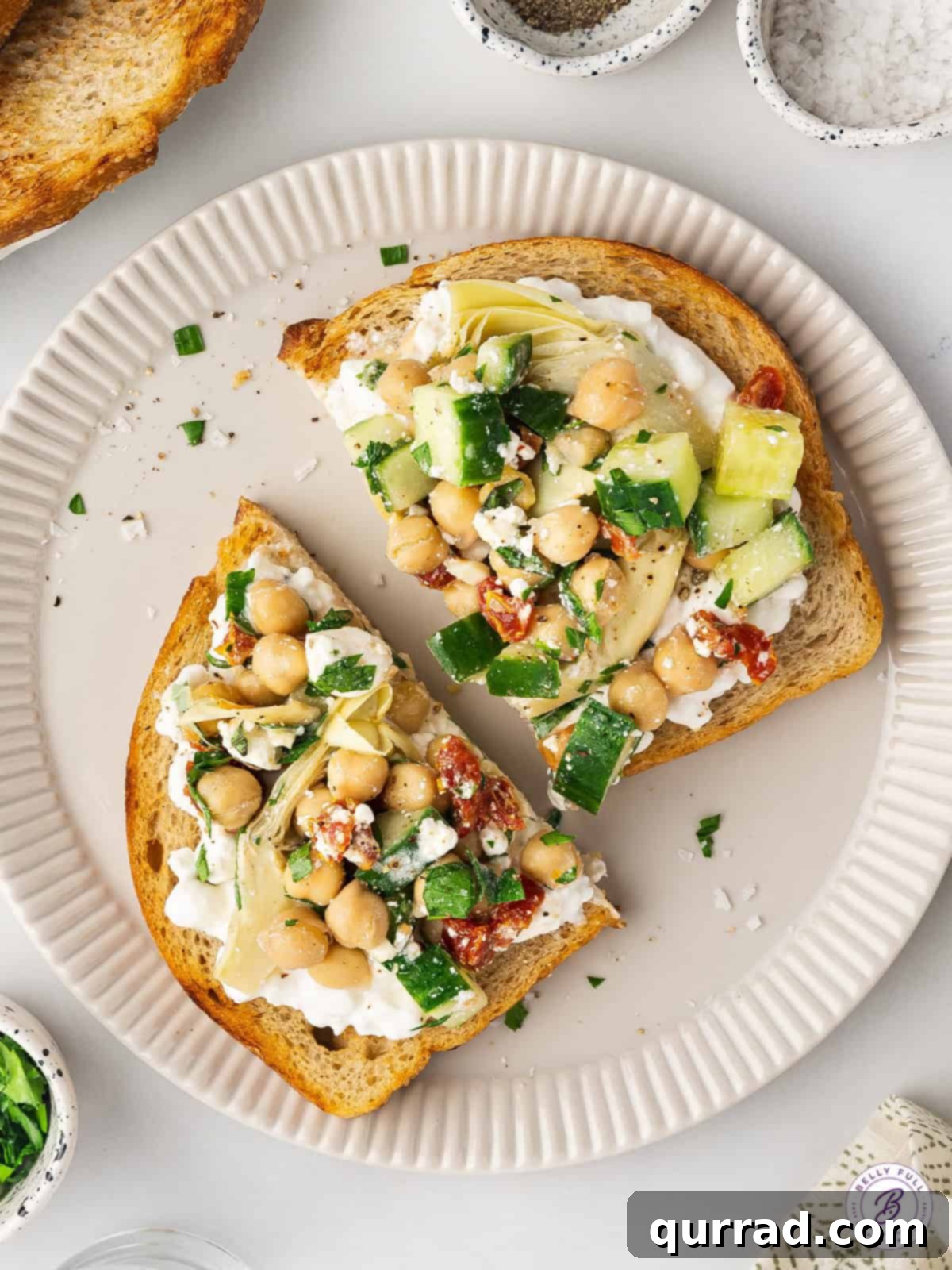 This Chickpea Salad and Cottage Cheese Toast features creamy cottage cheese on a thick slice of toast topped with a savory chickpea salad. Overhead view of a slice of cottage cheese toast with chickpea salad