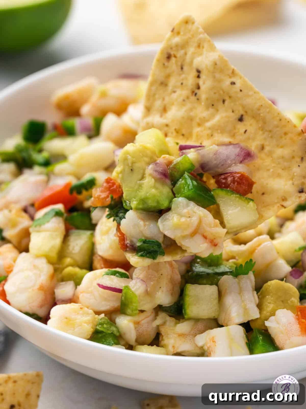 Zesty Lime Shrimp Ceviche 4 shrimp ceviche scooped on tortilla chip, ready for a bite
