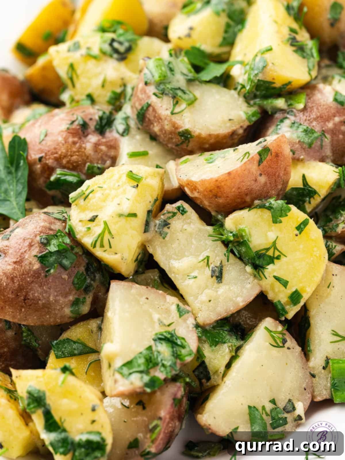 Close-up shot of French Potato Salad, showcasing the tender potatoes glistening with herby vinaigrette.