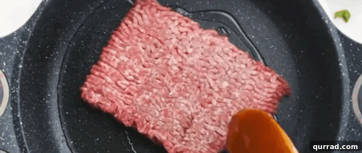 Ground pork sizzling in a large nonstick skillet over medium-high heat, beginning to brown and char on the edges.