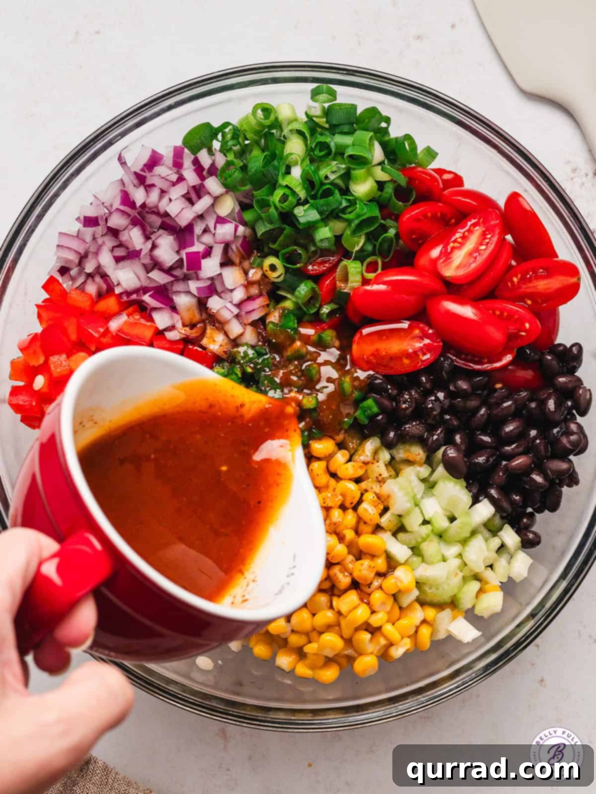 Vibrant Tex-Mex Couscous Salad 5 vinaigrette being poured into bowl with salad ingredients