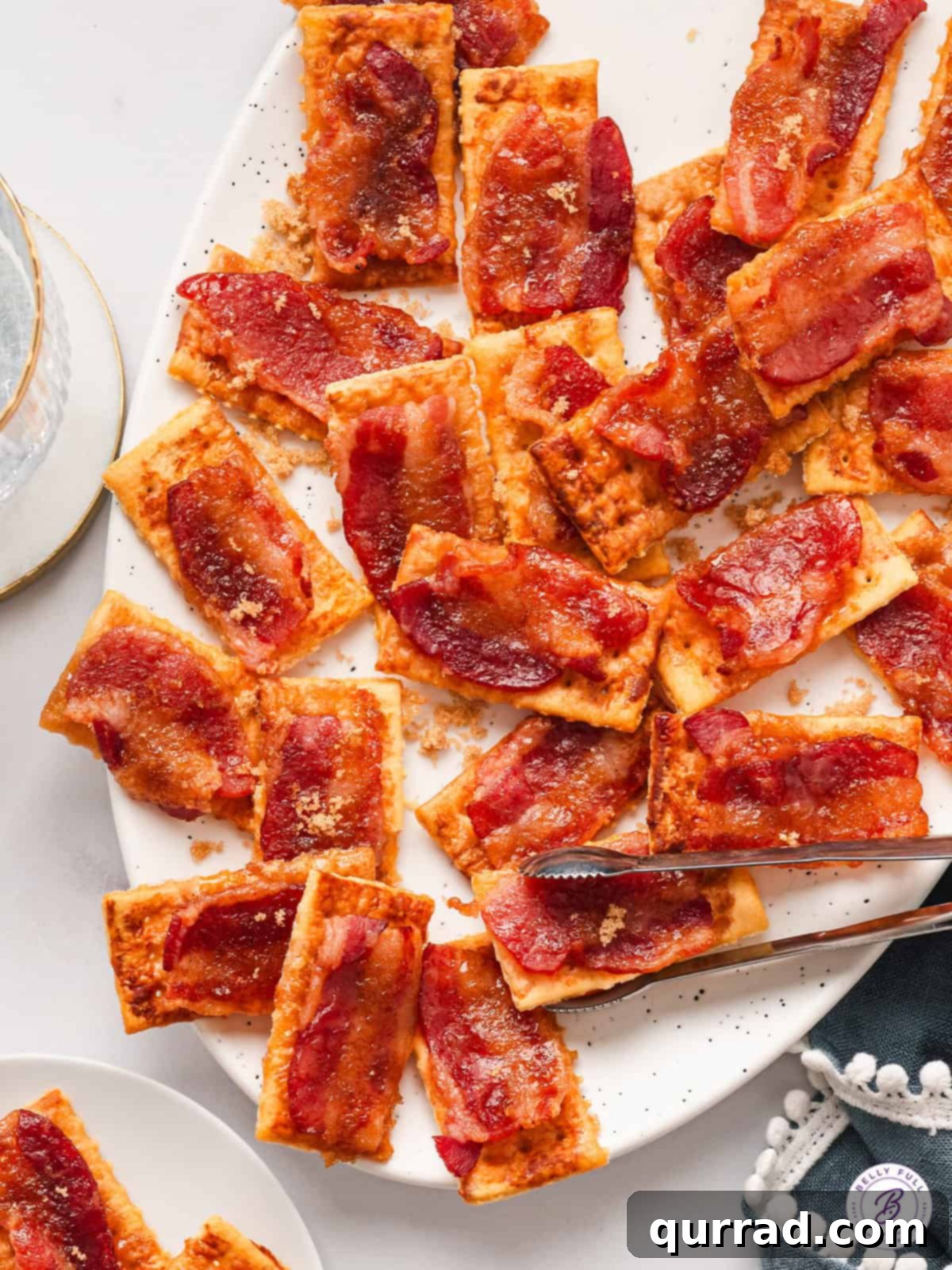 A festive plate piled high with golden-brown candied bacon crackers, ready to be served.