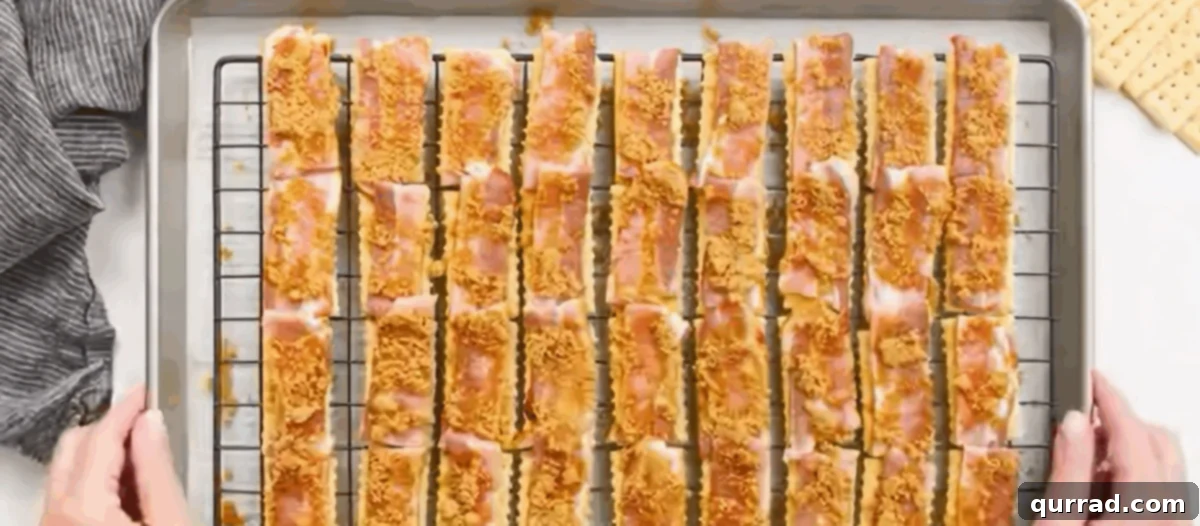A sprinkle of brown sugar and cayenne pepper mixture coating the bacon on each cracker.
