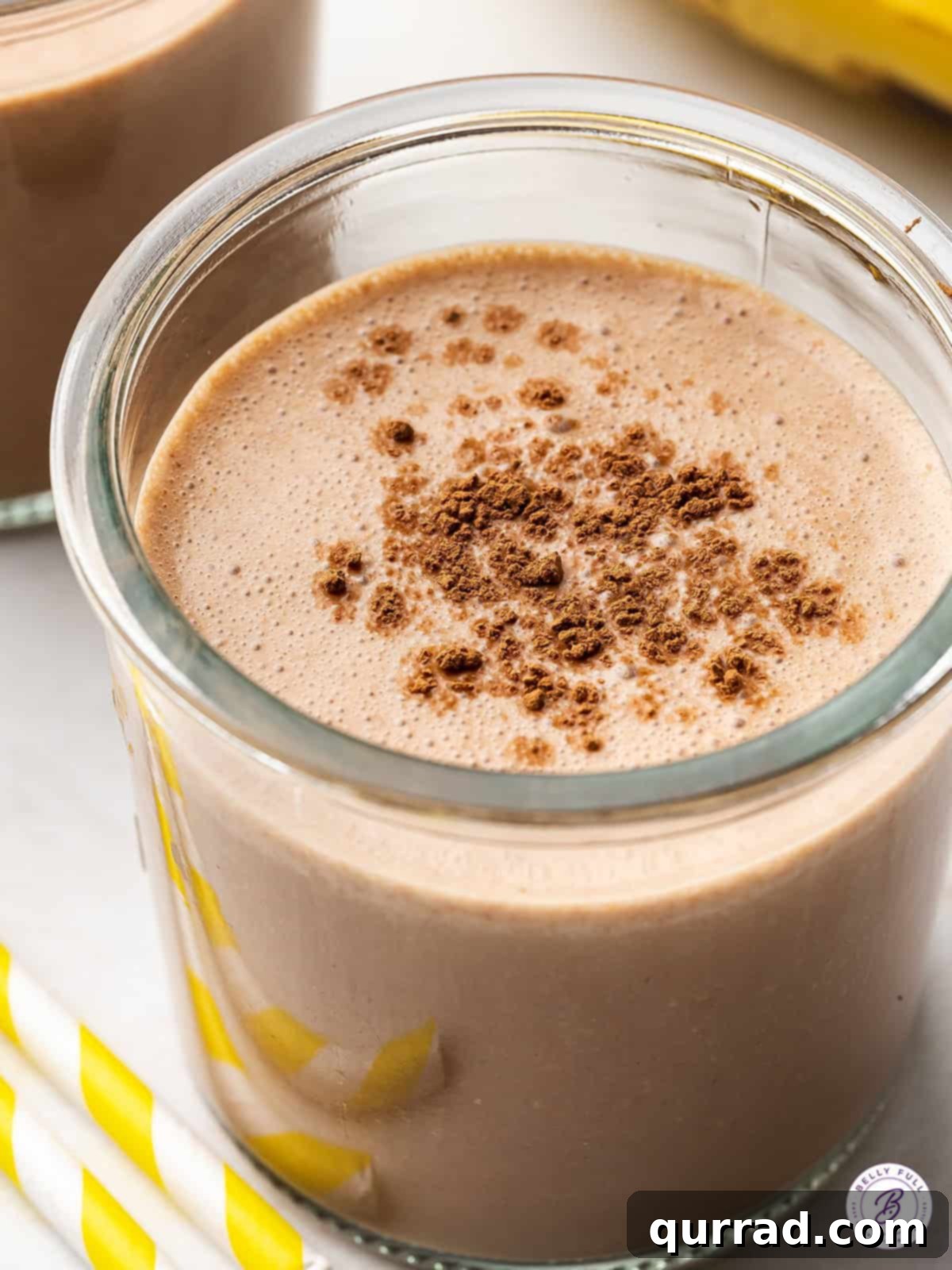 An inviting overhead view of a chocolate banana smoothie in a glass, garnished with a straw, ready for a refreshing sip.