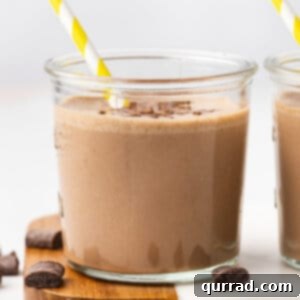 Chocolate banana smoothie in a glass with a yellow straw