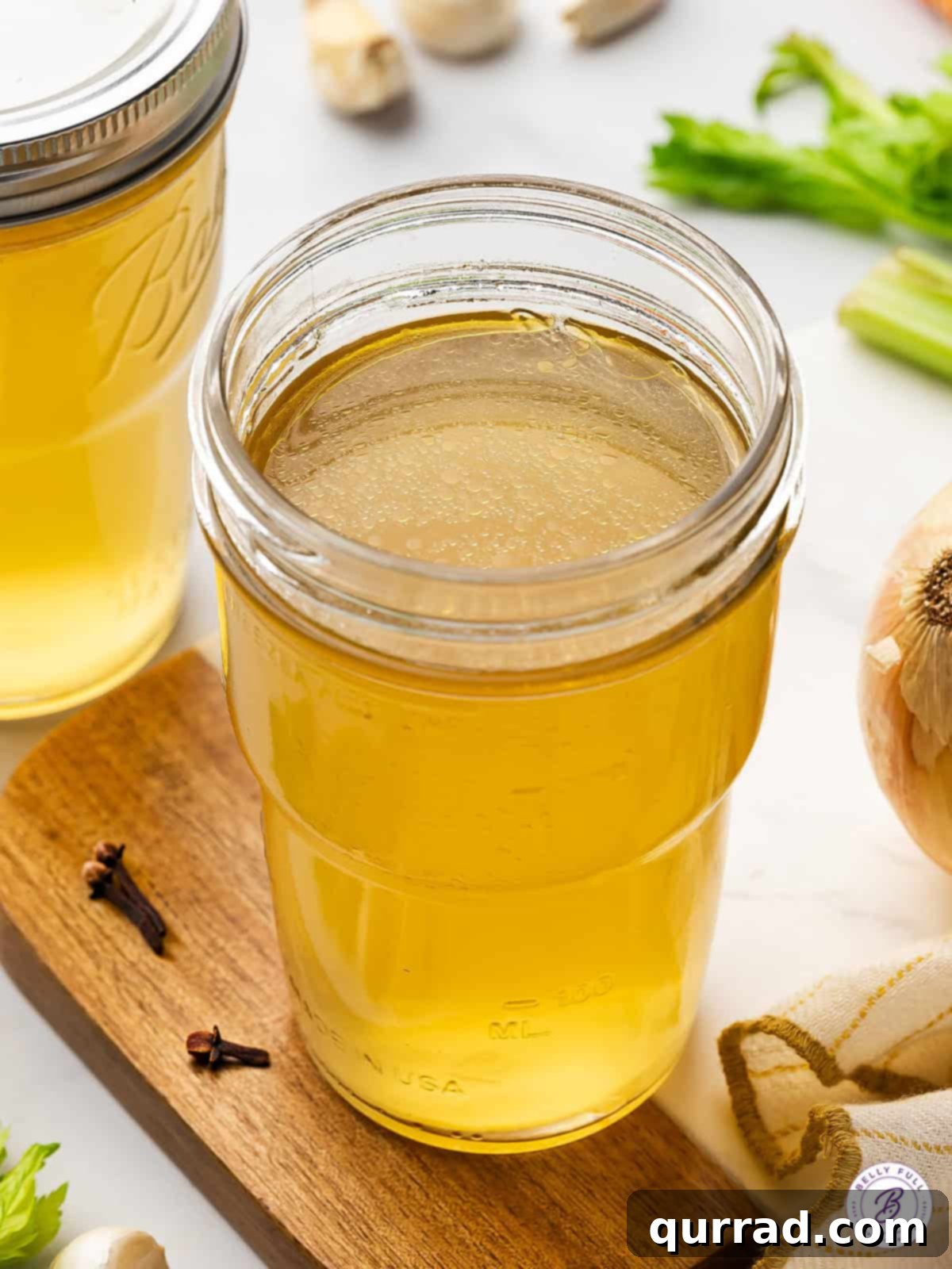 Golden Homemade Chicken Stock in a Mason Jar An overhead view of a sparkling glass jar filled with rich, golden homemade chicken stock.