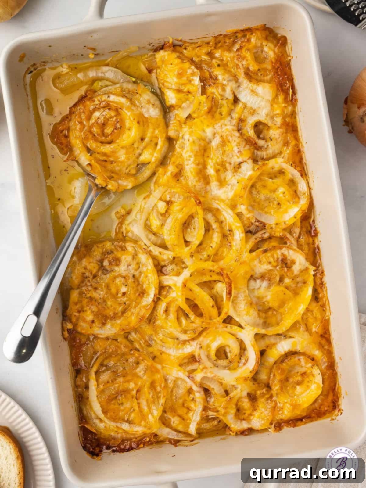 Overhead view of a baking dish of Tennessee onions, golden brown and bubbling with cheese.