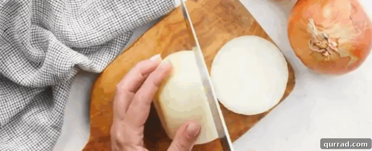 Slicing sweet Vidalia onions into thin rounds on a wooden cutting board.