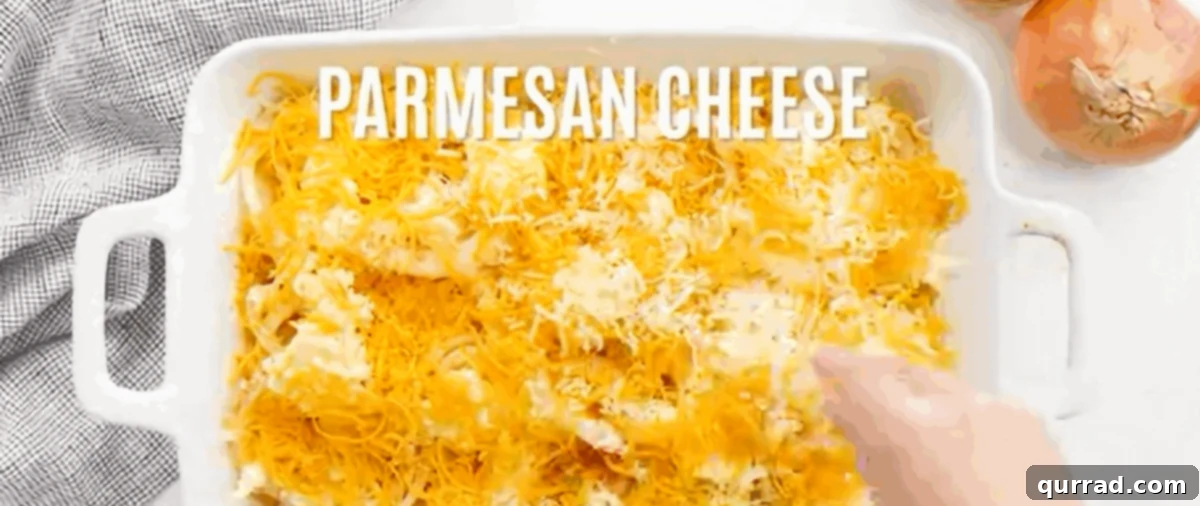 Generously sprinkling shredded cheese over the onion and butter layers in the baking dish.