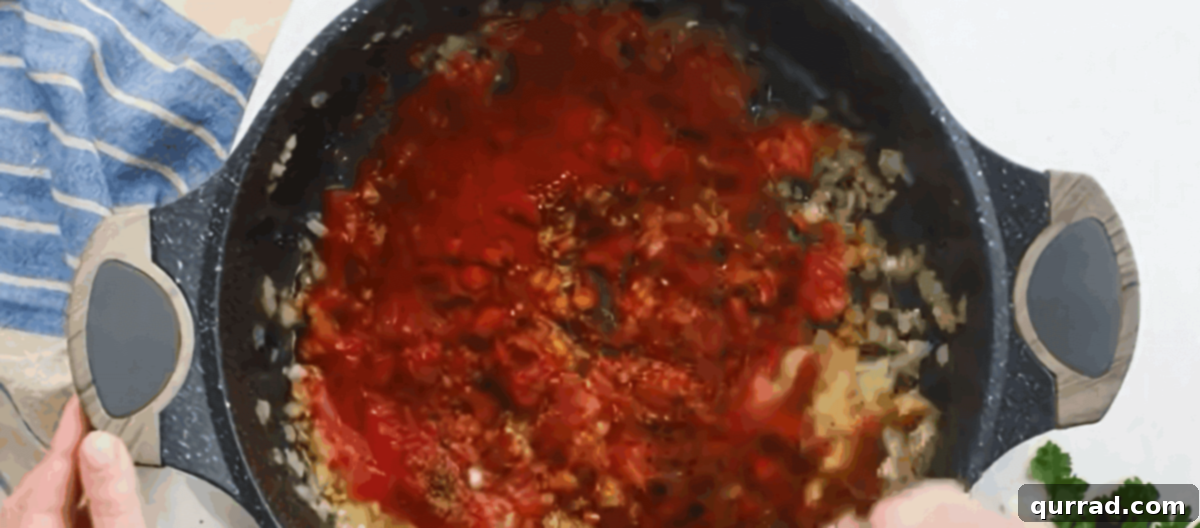 Rich Hungarian Paprika Chicken 5 Adding garlic, tomato sauce, and Hungarian paprika to the skillet to create the base of the paprikash sauce.