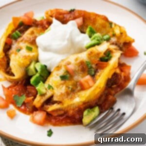A beautifully plated taco stuffed shell, garnished with a dollop of sour cream.