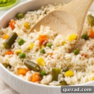 A wooden spoon stirring a bowl of mixed veggies and rice, showcasing the ingredients and final presentation.