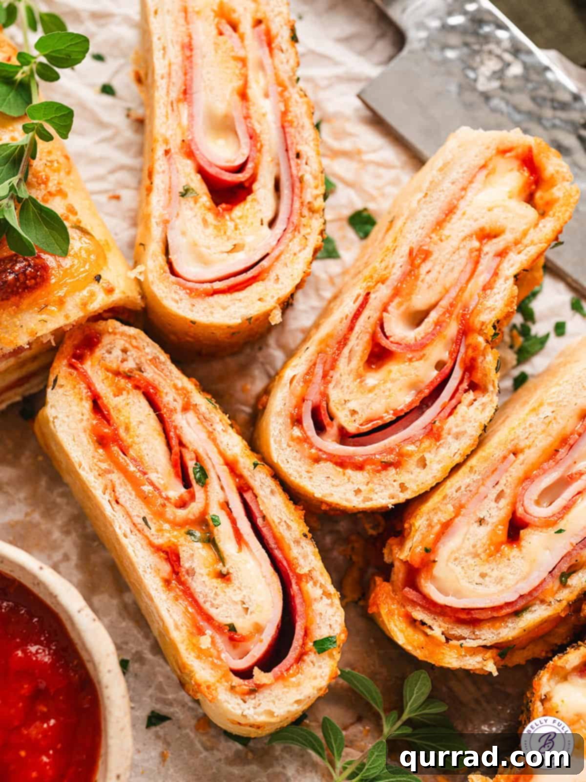 Close up overhead view of perfectly cut slices of stromboli, showing the distinct layers of dough, sauce, cheese, and meats.