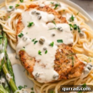 A plate of chicken with caper cream sauce over pasta