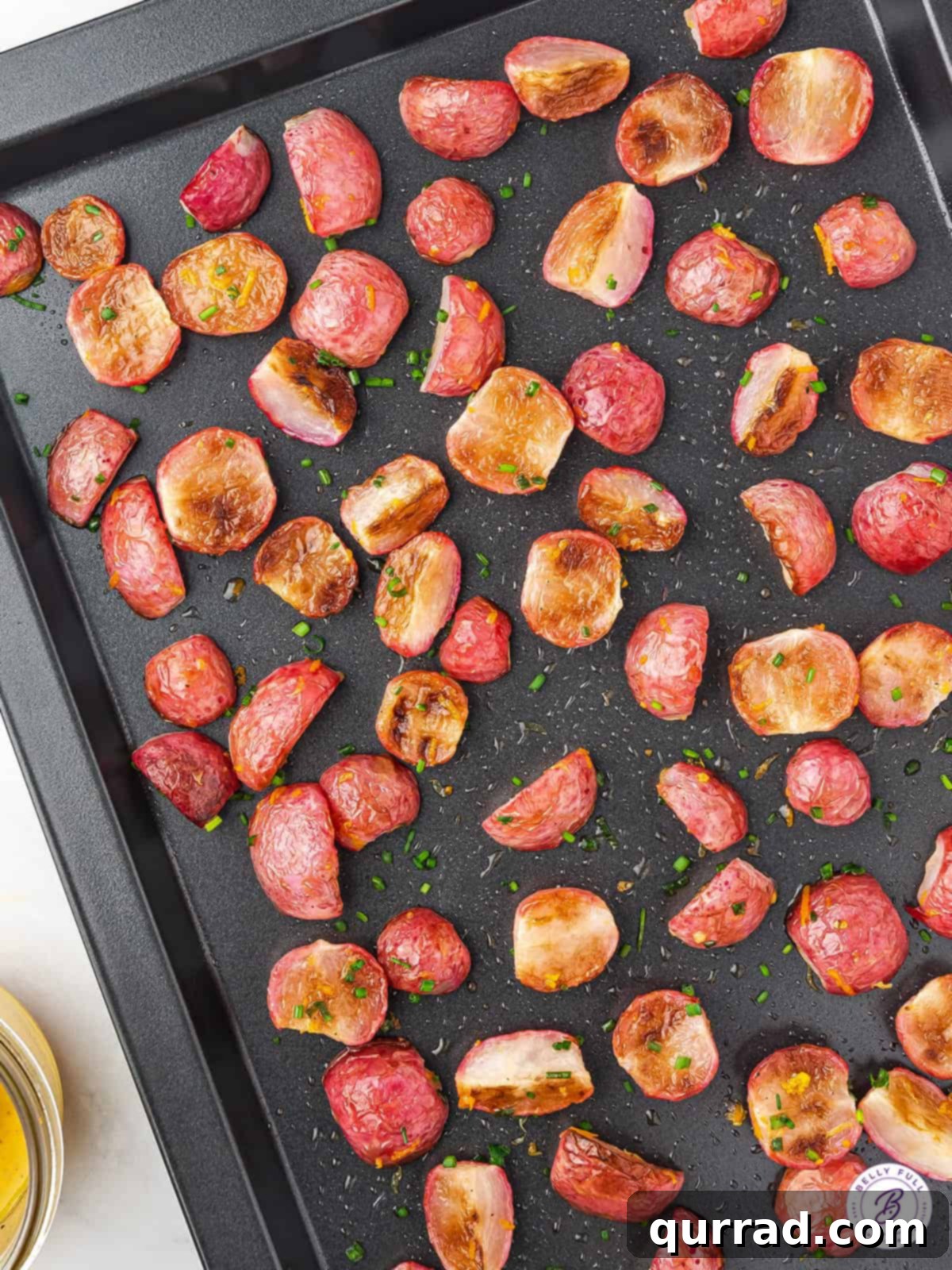 Roasted radishes on a baking sheet, showcasing their crisp edges and vibrant colors.