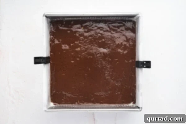 Fudge mixture smoothly spread into a parchment-lined baking dish.