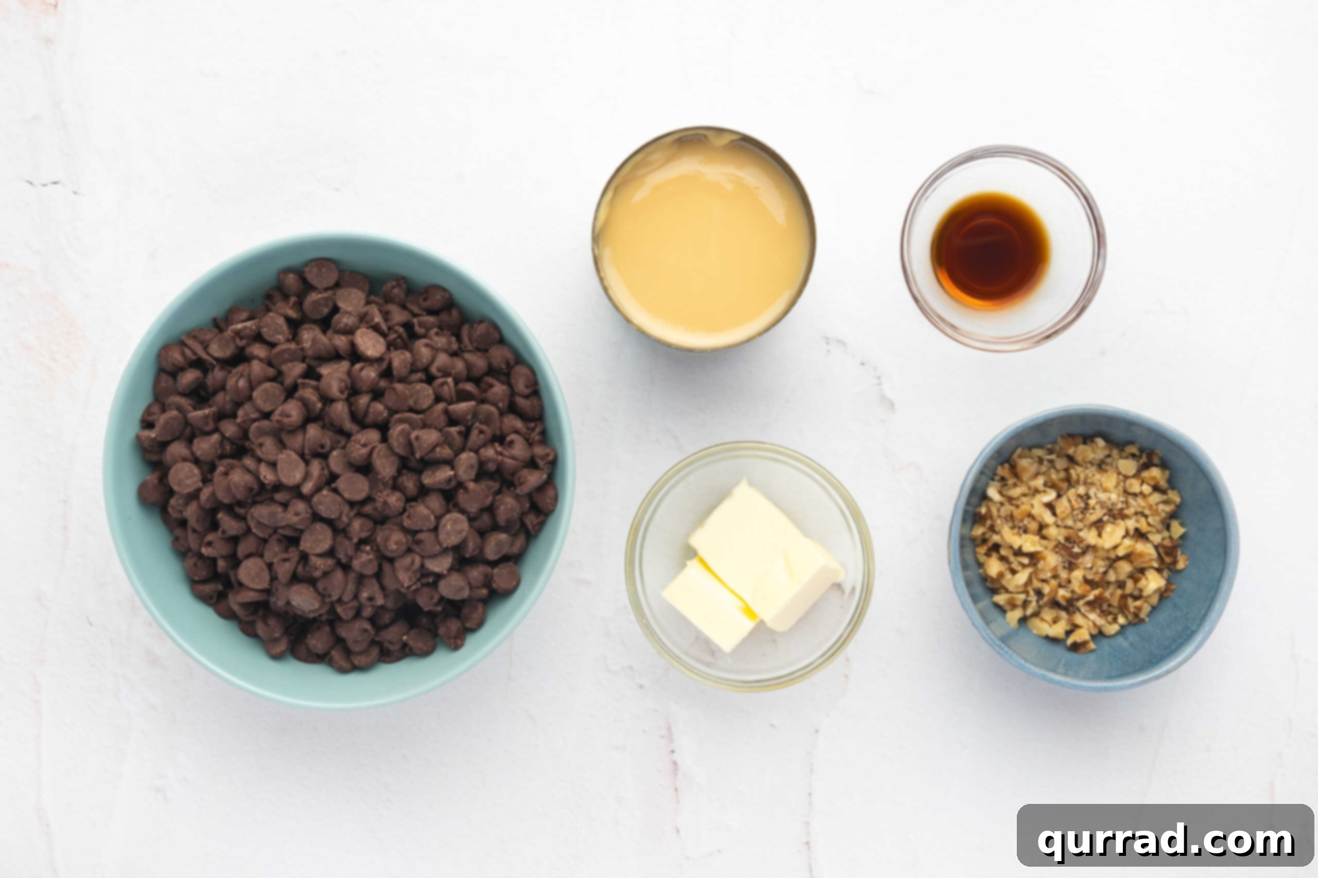 Decadent Chocolate Fudge 3 All the simple ingredients for homemade chocolate fudge, neatly laid out on a kitchen counter, including chocolate chips, butter, condensed milk, vanilla, and walnuts.