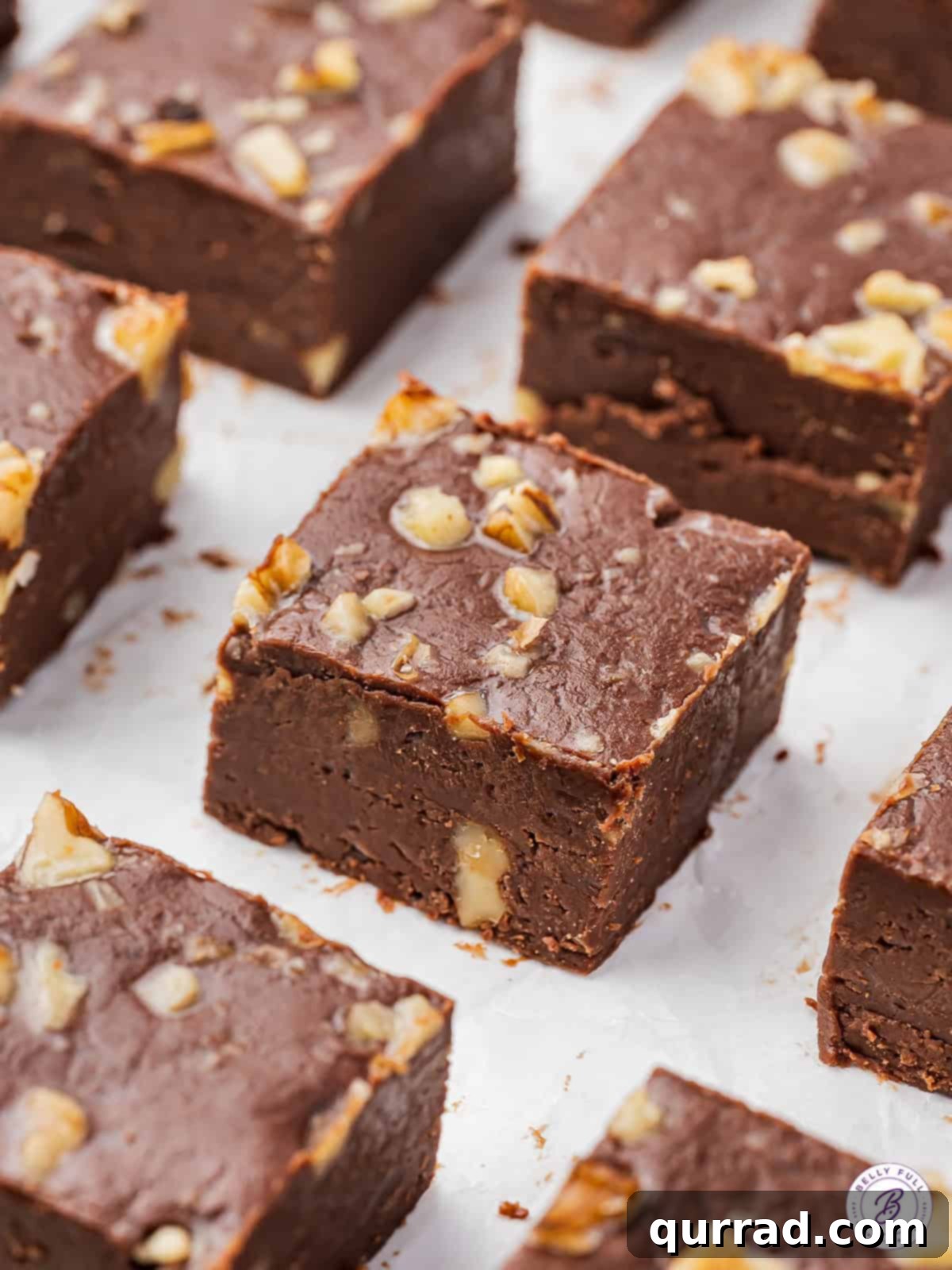 Decadent Chocolate Fudge 4 An overhead view of perfectly cut squares of chocolate fudge, garnished with chopped walnuts, ready to be served.