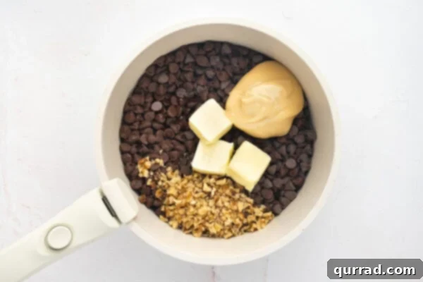 Chocolate chips, condensed milk, butter, and chopped walnuts in a sauce pan, just beginning to melt.