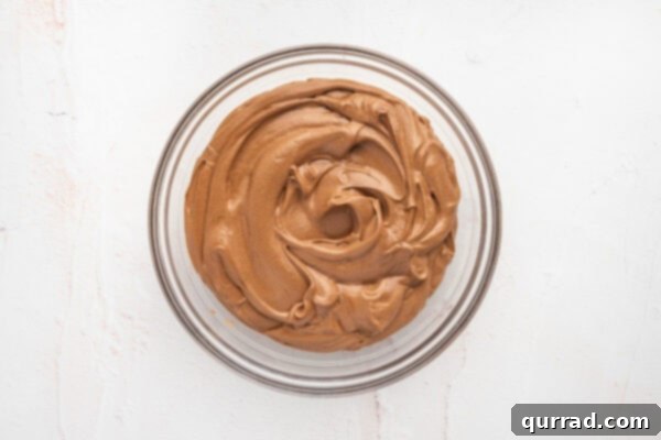 Finished French silk pie filling, light and airy, swirling in a glass mixing bowl.