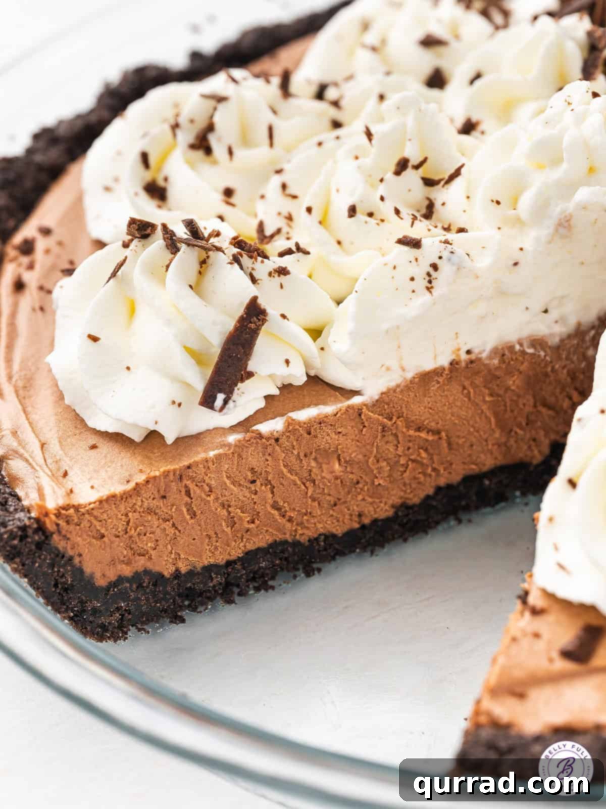 Decadent Chocolate Silk Pie 4 A beautiful side view of a French Silk Pie, with a slice already removed, showing the layers of crust, filling, and whipped cream.