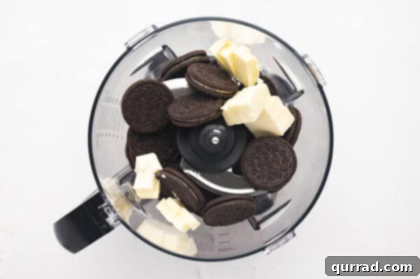 Oreos and cubed butter in a food processor, ready to be processed for the pie crust.