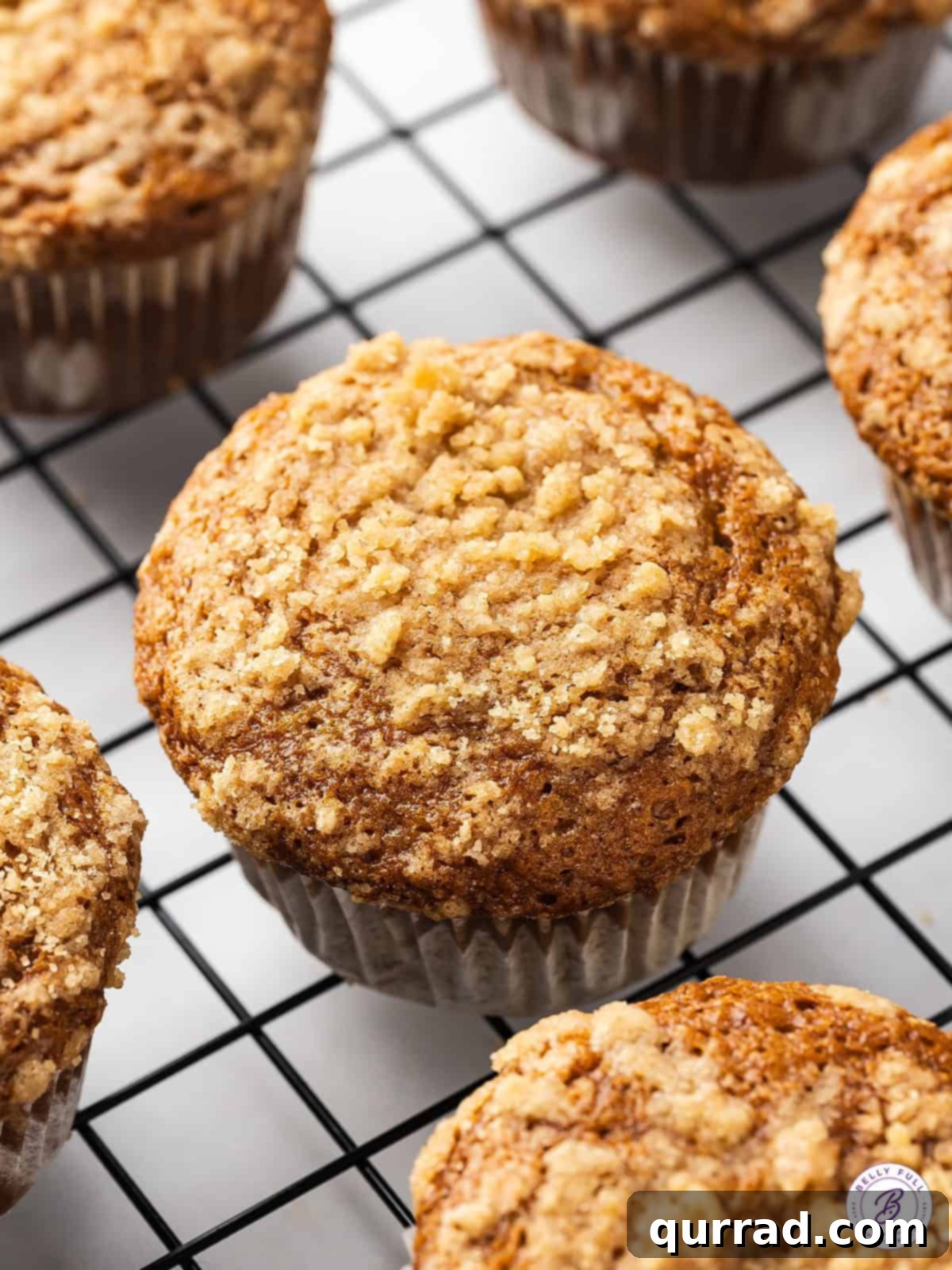 Freshly baked banana muffins with crumb topping cooling on a wire rack