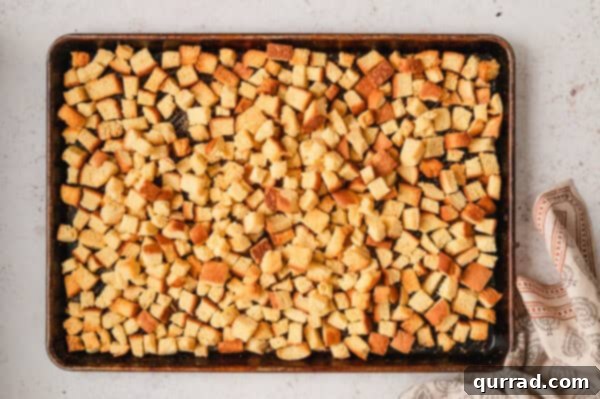 Cubes of potato bread on a baking sheet, drying out before being used in the stuffing