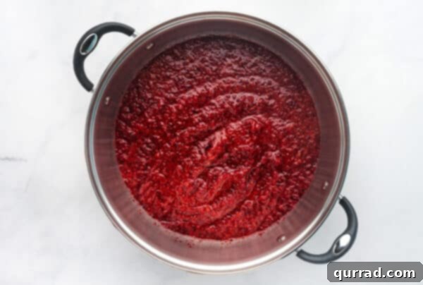 Yuletide Grooves 5 Blended cranberries and strawberries in a pot on the stovetop.