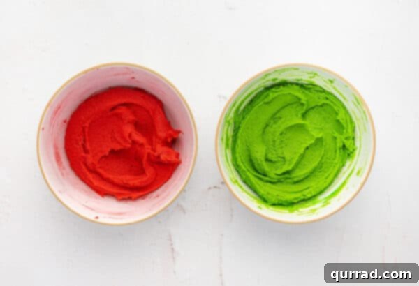 Spritz cookie dough in two separate bowls, one colored with red food coloring and the other with green food coloring.