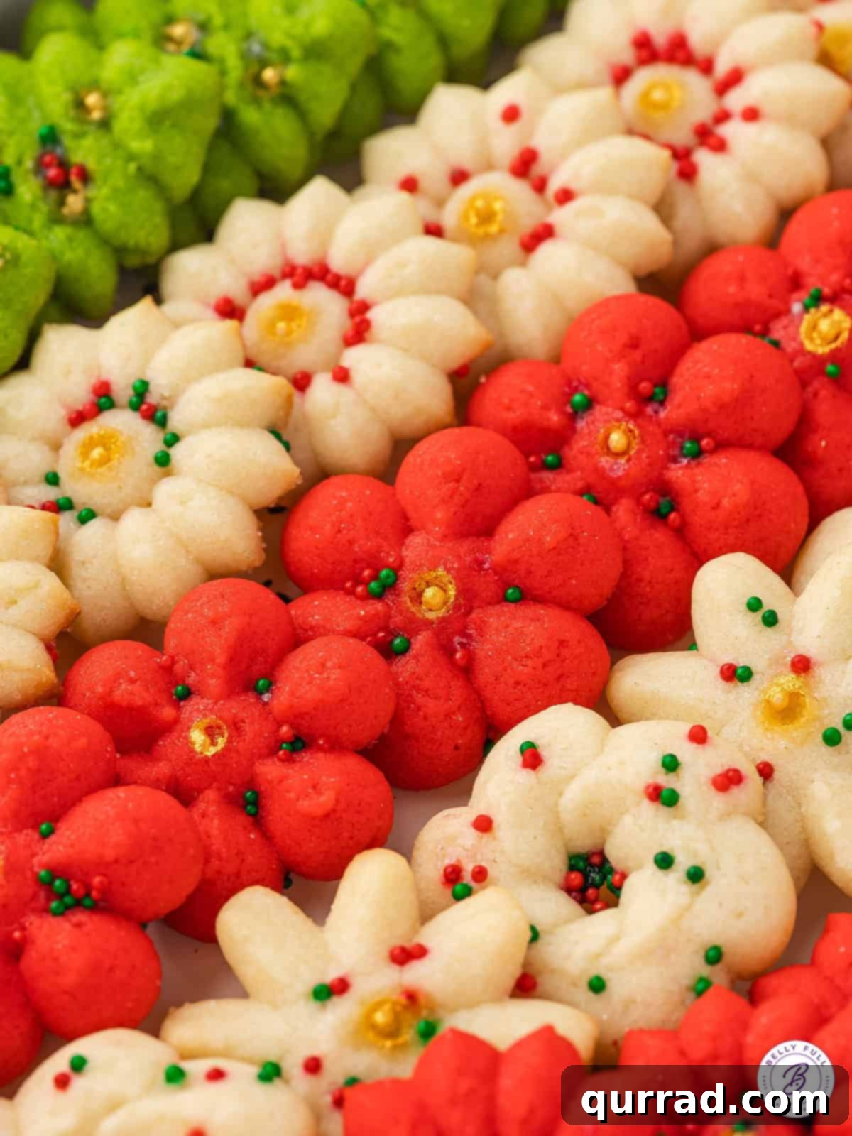 Pressed Butter Cookies 5 Overhead close-up view of a platter filled with perfectly formed and festive Christmas spritz cookies, highlighting their intricate designs and colorful sprinkles.