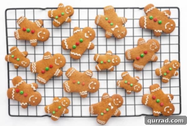 Decorated gingerbread men cookies on a wire rack, with various white icing patterns.